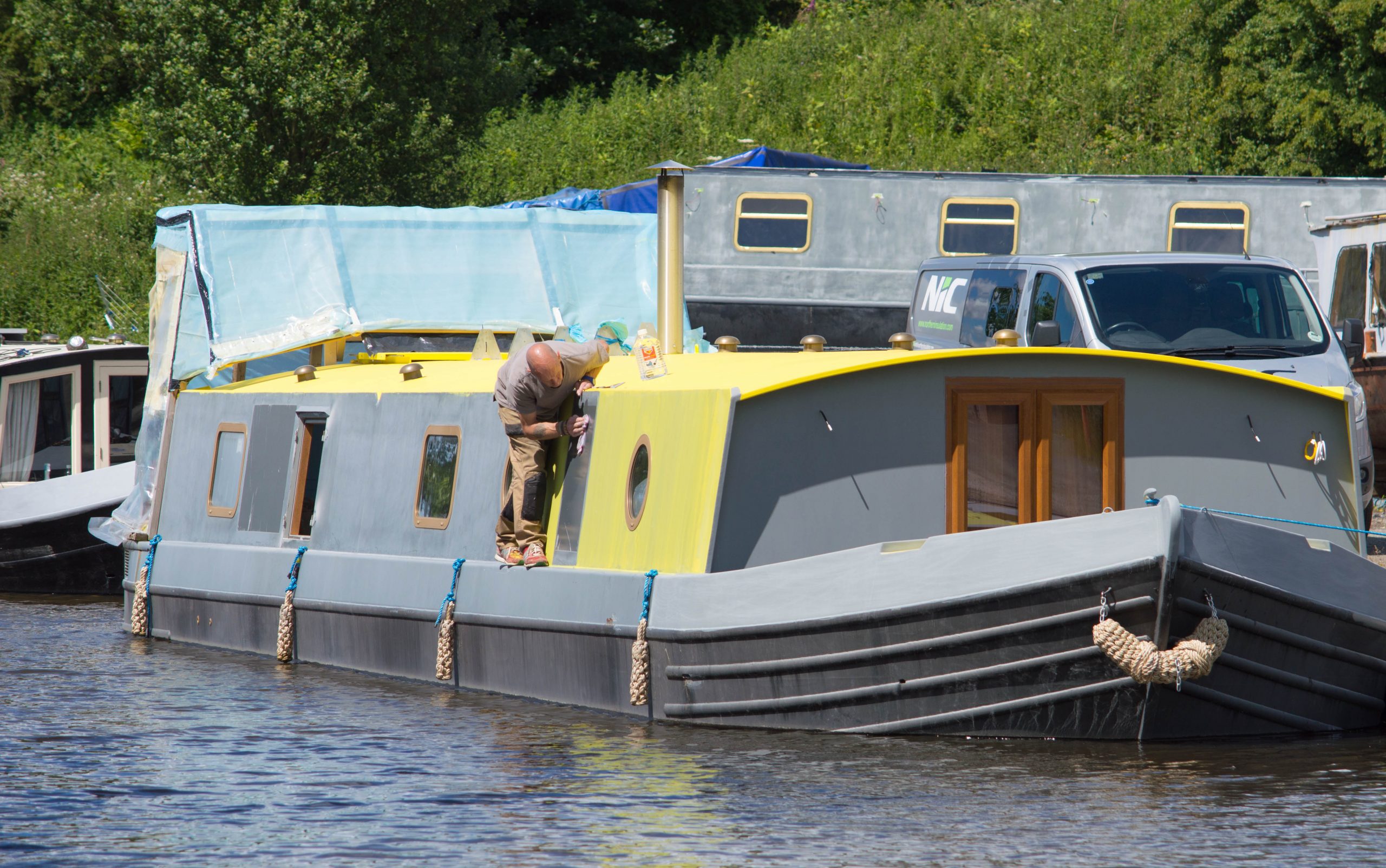 Painting a canal boat on the water